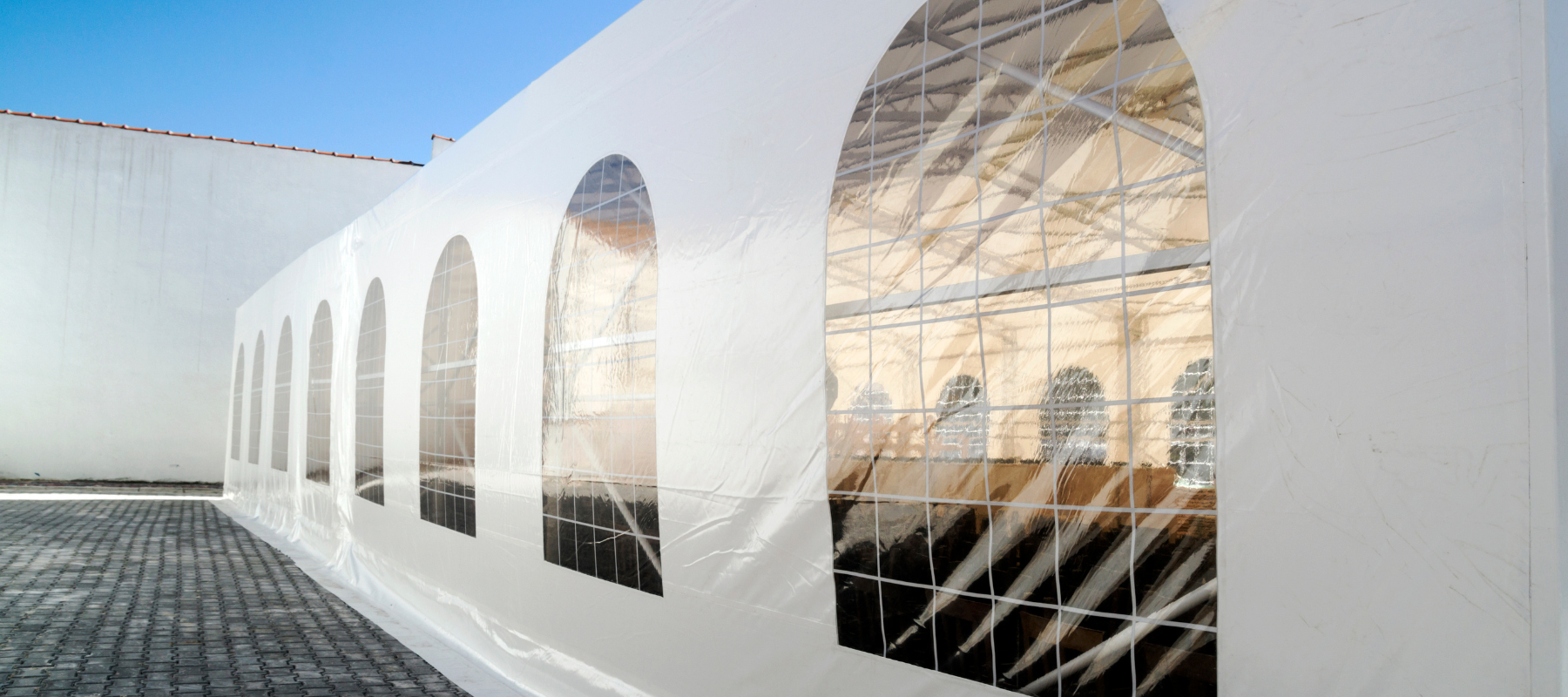 A white tent with plastic windows.